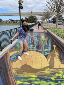 girl on three dimensional chalk drawing at epcot festival of the arts